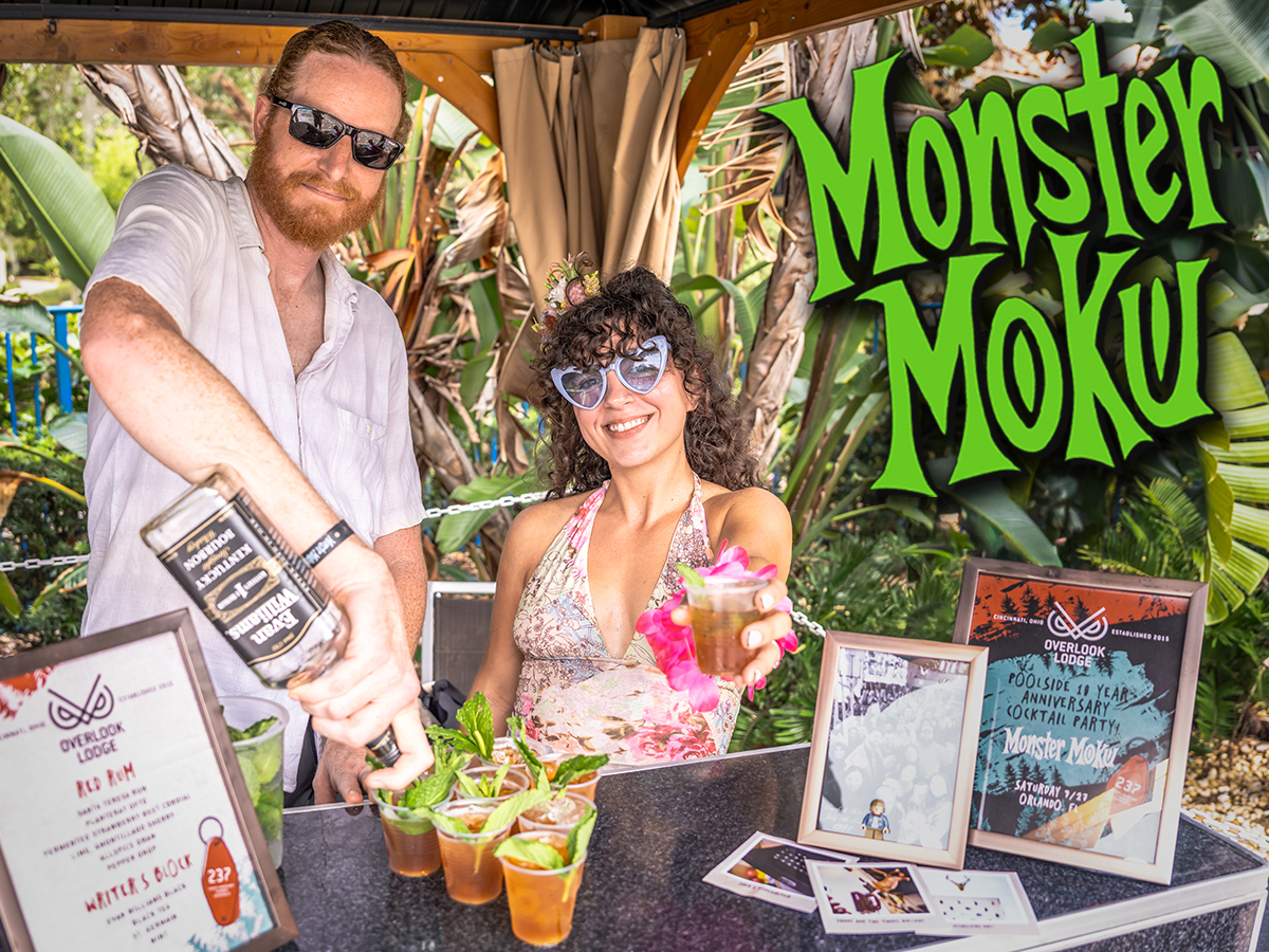 Smiling guest enjoying a tropical cocktail at Monster Moku